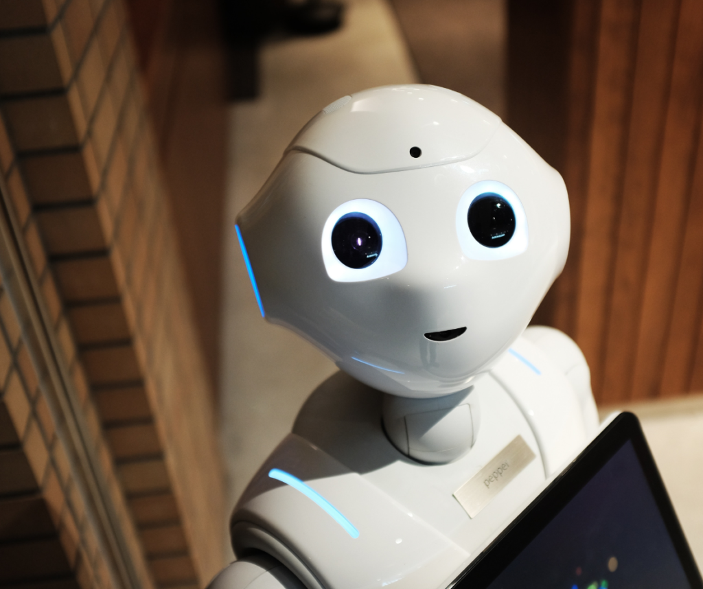 Petit robot androïde mignon qui regarde vers le haut, vers la caméra, pour symboliser la tension entre froideur technique et humanité nécessaire au recrutement